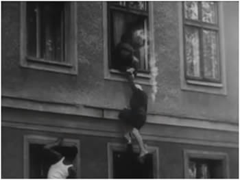 1961 - una donna che denta la fuga
la casa si trova sul confine; la finestra da sull'ovest;
viene tirata su dai Vopos e tirata giù da persone dell'ovest.
La nuvoletta a destra della donna è la scia di un proietille.